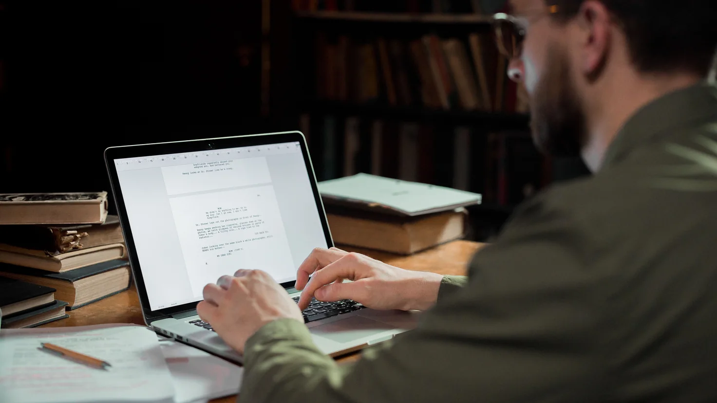 Mann liest ein Dokument auf dem Bildschirm seines Laptops